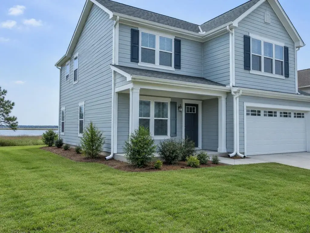 New two-story home with short downspout elbows and fresh sod