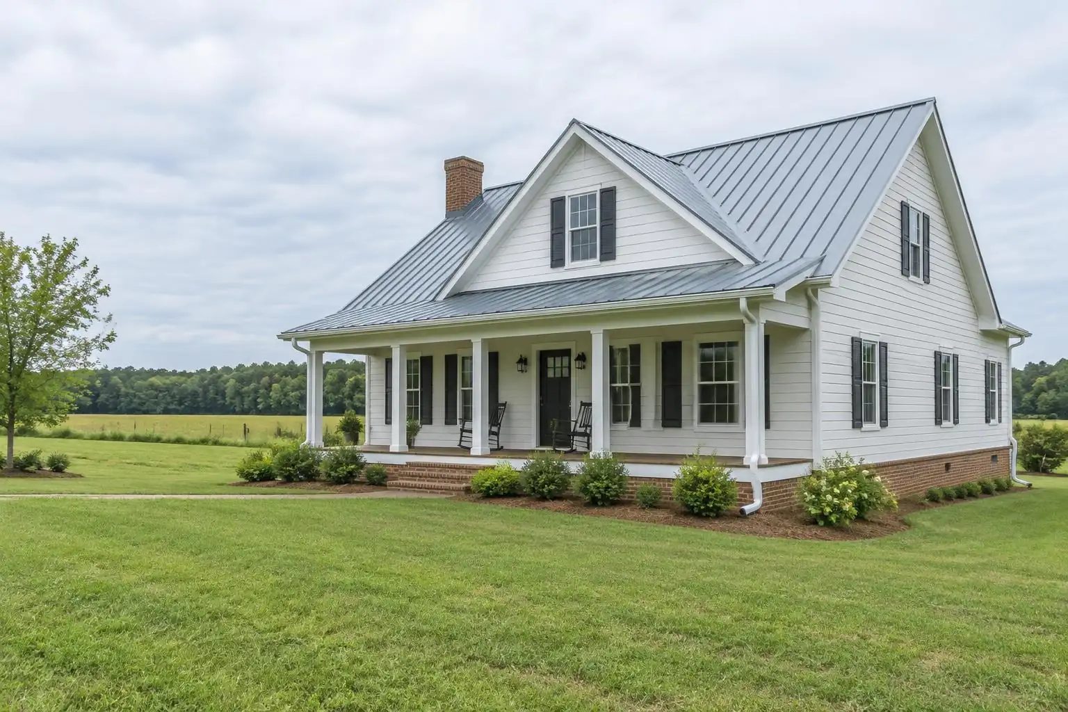 Rural farmhouse with a metal roof and gutters beside an open field
